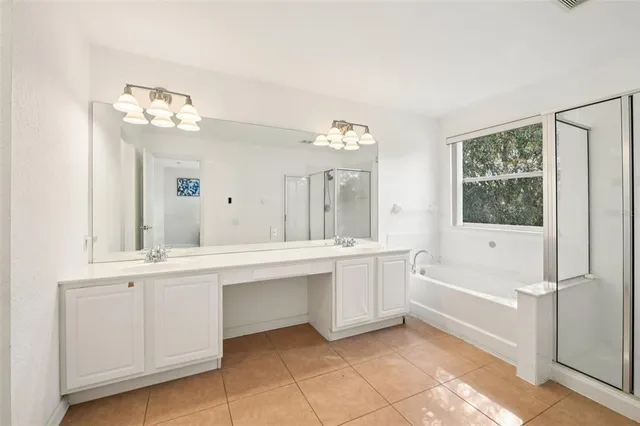 a large white kitchen with a sink and dishwasher with white cabinets