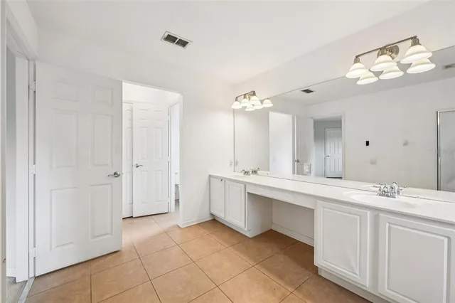 a spacious bathroom with a double vanity sink mirror and bathtub