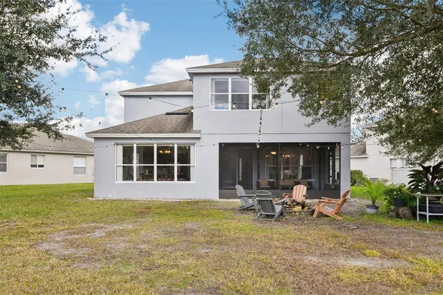 a view of a house with backyard and sitting area
