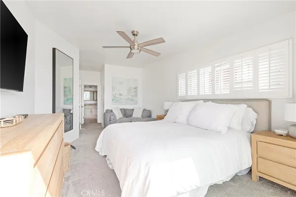 a spacious bedroom with a bed and a flat screen tv