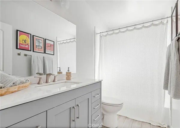 a bathroom with a granite countertop sink a toilet a shower and a mirror