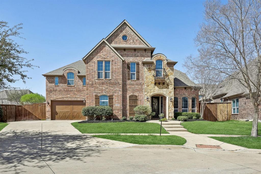 6705 Sigma Lane Frisco, TX 75035 - Photo 1 of 8 Traditional brick two-story residence featuring a prominent stone facade entrance with an arched doorway
