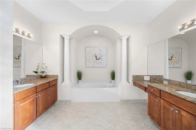 a spacious bathroom with a granite countertop tub sink and mirror