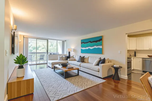 a living room with furniture floor to ceiling window and a flat screen tv