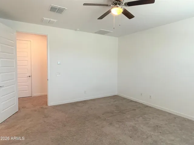 an empty room with closet and chandelier fan