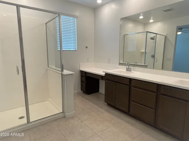 a bathroom with double vanity and a shower