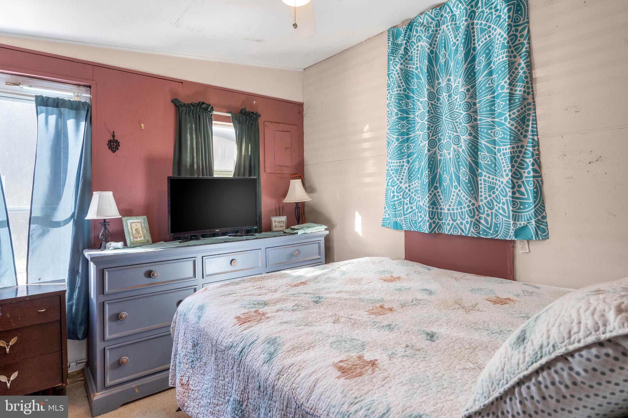 11451 Gum Point Road, Unit 17 Berlin, MD 21811 - Photo 11 of 21 a bedroom with a large bed and a flat tv screen on dresser