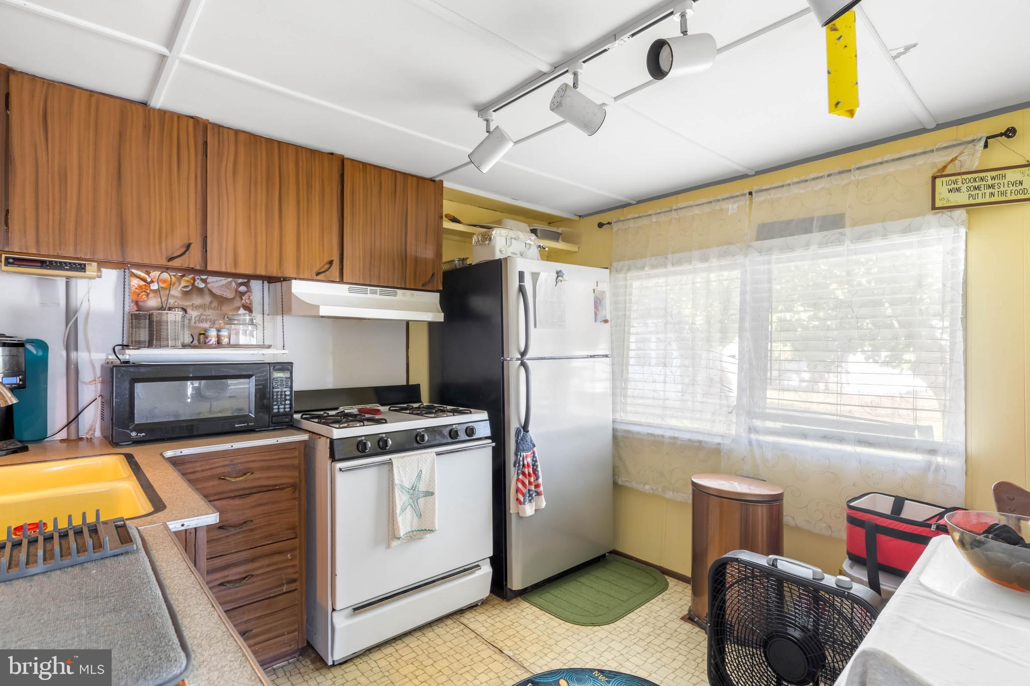 11451 Gum Point Road, Unit 17 Berlin, MD 21811 - Photo 13 of 21 a kitchen with a stove a refrigerator and furniture