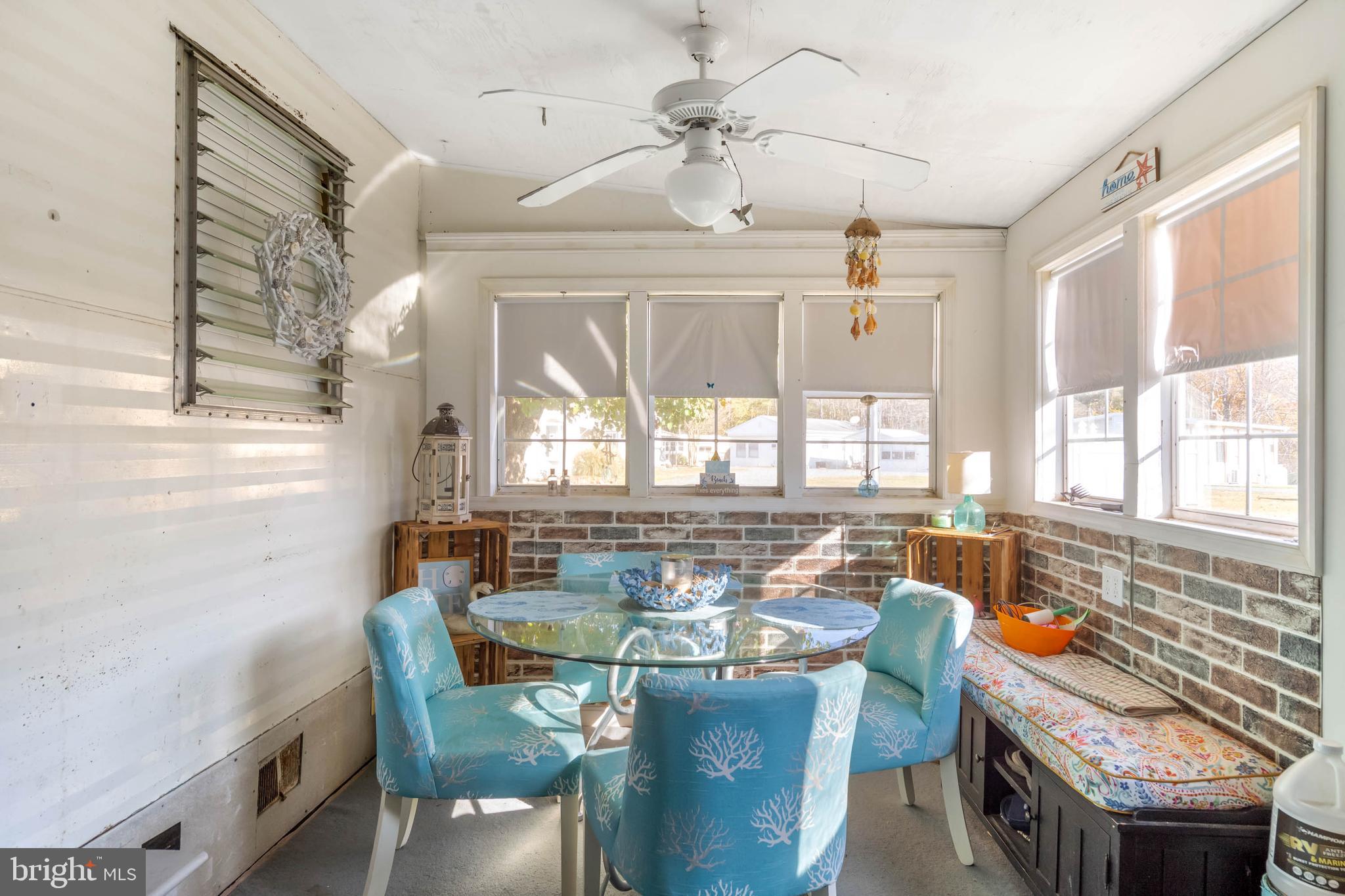 11451 Gum Point Road, Unit 17 Berlin, MD 21811 - Photo 6 of 21 a dining room with furniture a chandelier and wooden floor