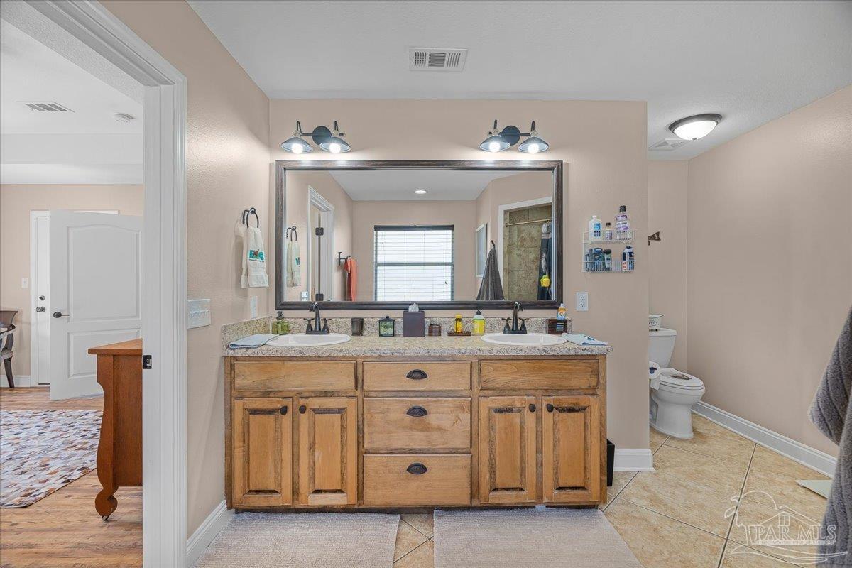 1766 Narrow Road Jay, FL 32565 - Photo 35 of 55 a bathroom with a granite countertop sink a toilet and a mirror