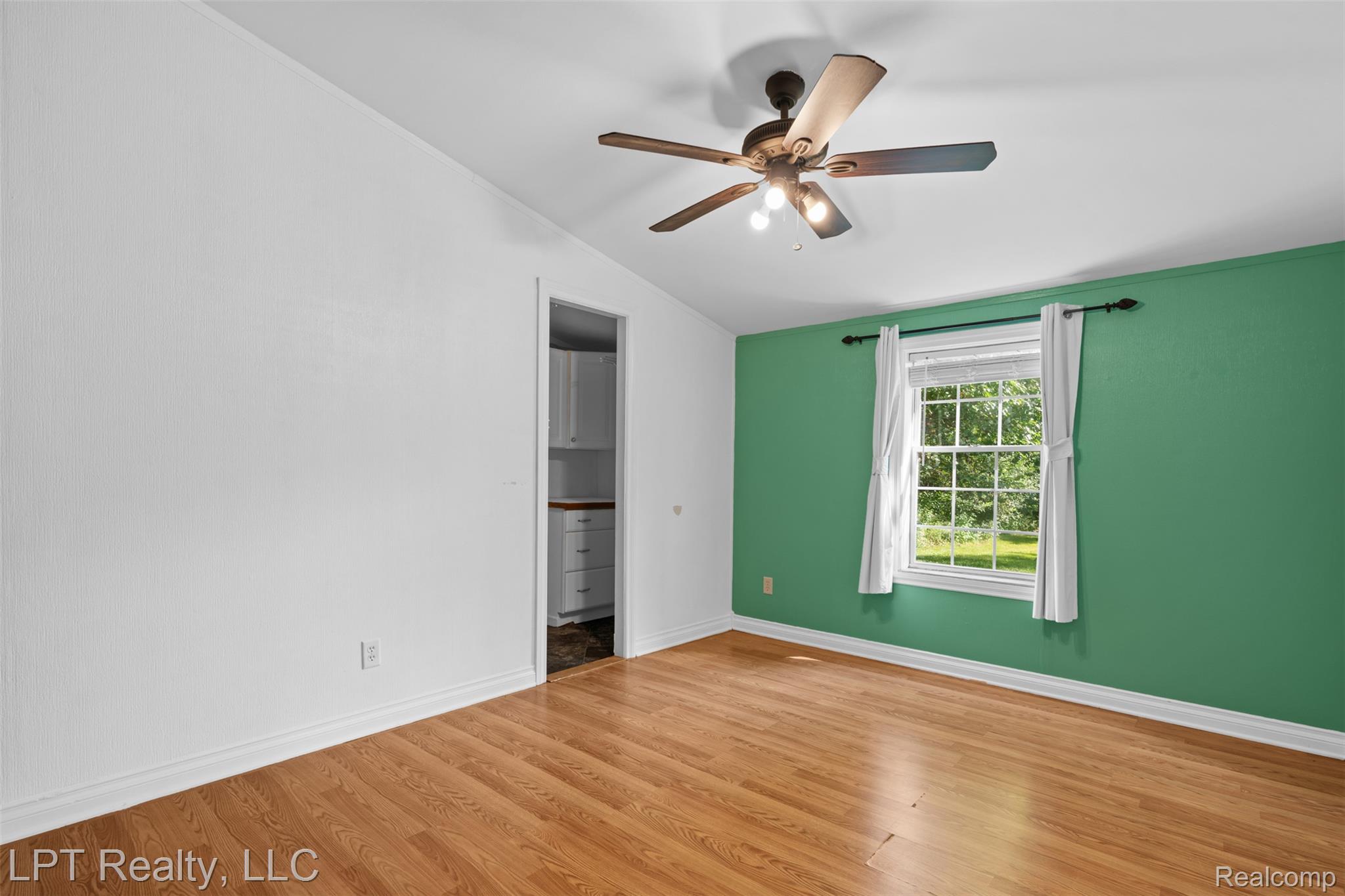 6271 East Potter Road Davison, MI 48423 - Photo 19 of 41 Unfurnished bedroom featuring lofted ceiling, wood finished floors, and ceiling fan