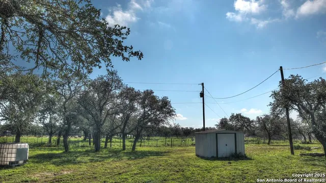 a view of a green field with trees