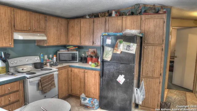 a kitchen with a refrigerator sink and cabinets