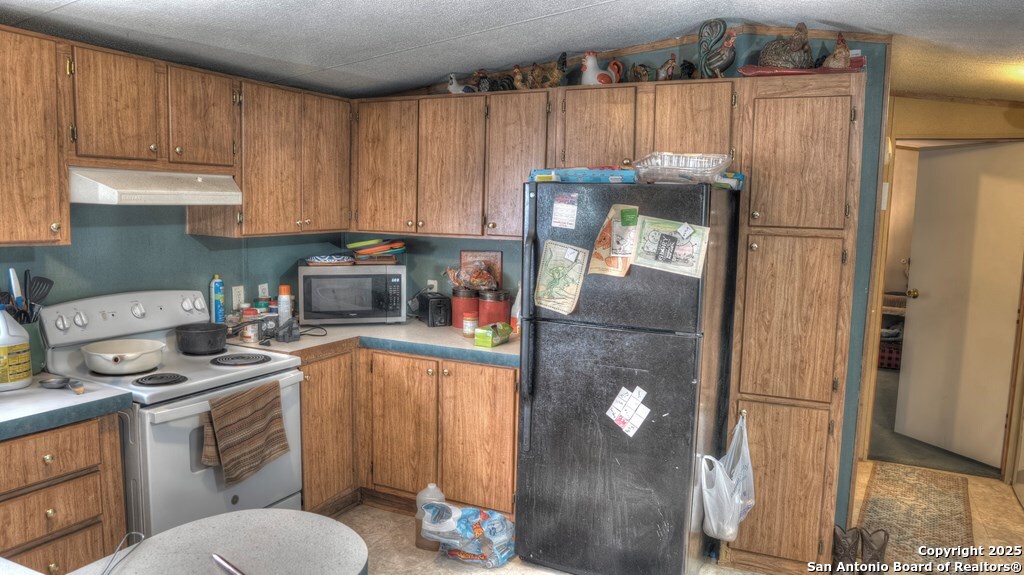 14832 Highway 41 Rocksprings, TX 78880 - Photo 5 of 21 a kitchen with a refrigerator sink and cabinets