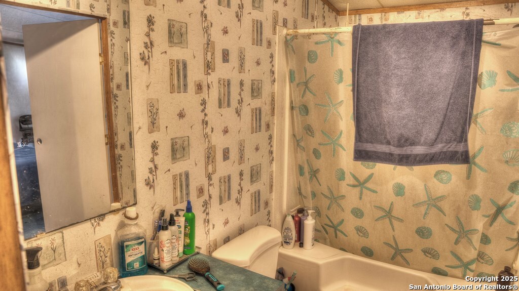 14832 Highway 41 Rocksprings, TX 78880 - Photo 7 of 21 a bathroom with a bathtub and shower curtain