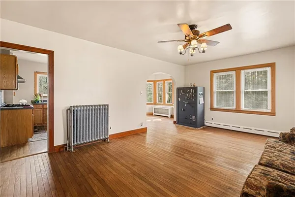 a view of an empty room with a window and wooden floor