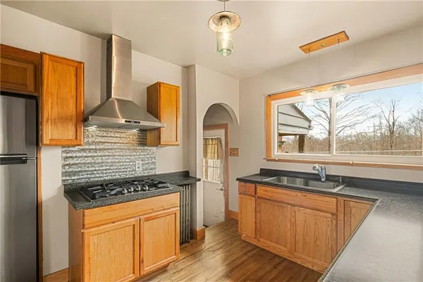 a kitchen with stainless steel appliances granite countertop a stove a sink and a refrigerator