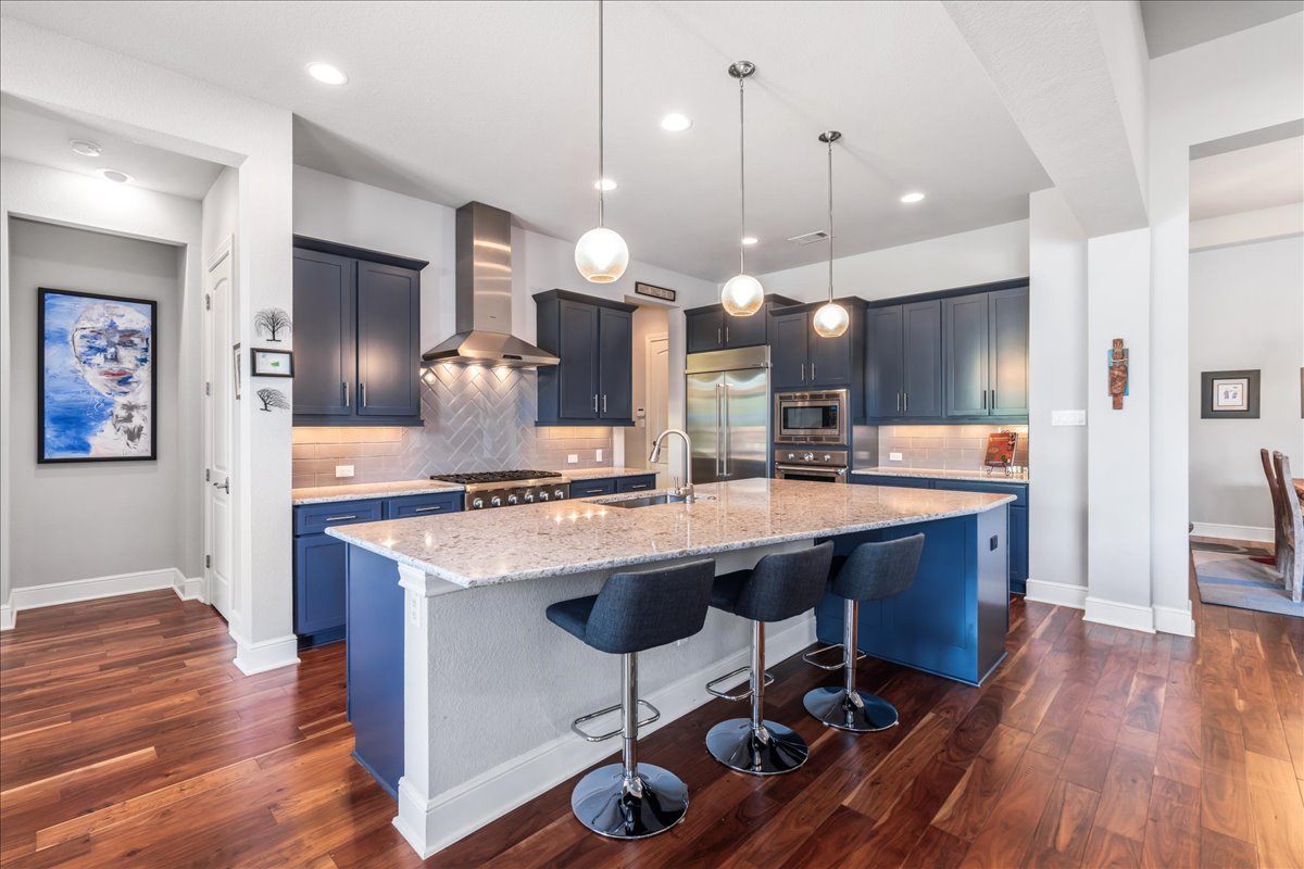 413 Montalcino Lane Georgetown, TX 78628 - Photo 17 of 40 a kitchen with a table chairs refrigerator and wooden floor