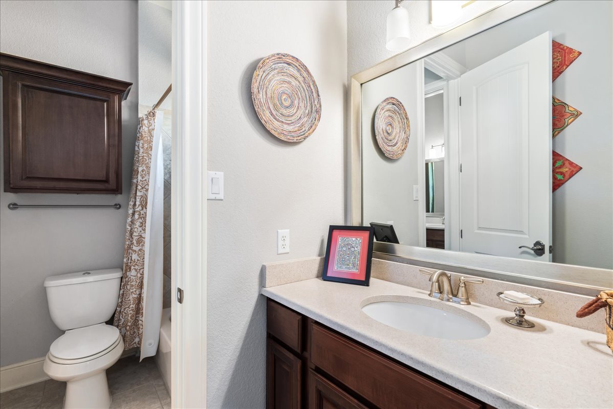 413 Montalcino Lane Georgetown, TX 78628 - Photo 31 of 40 a bathroom with a toilet sink vanity and mirror
