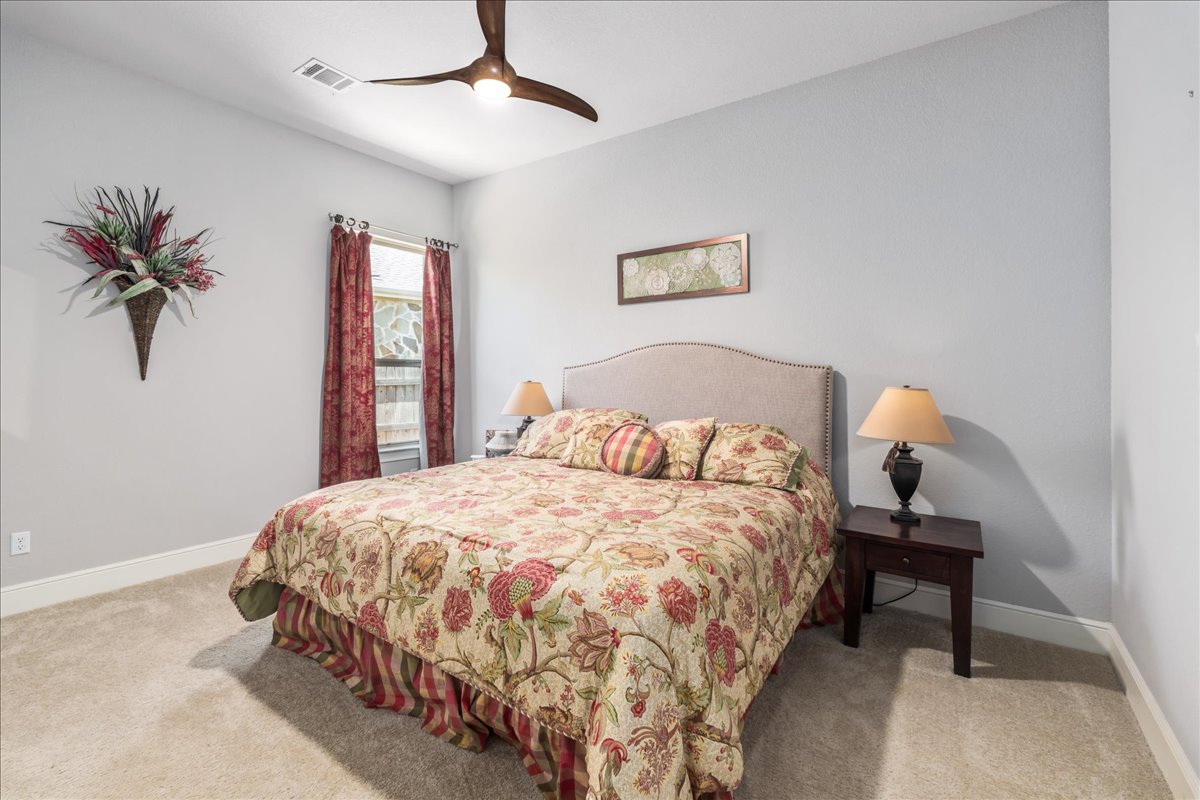 413 Montalcino Lane Georgetown, TX 78628 - Photo 32 of 40 a bedroom with a bed and a chandelier