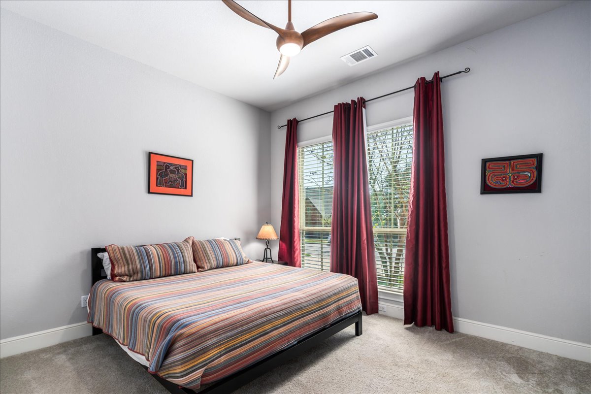 413 Montalcino Lane Georgetown, TX 78628 - Photo 9 of 40 a bedroom with a large bed and a chandelier