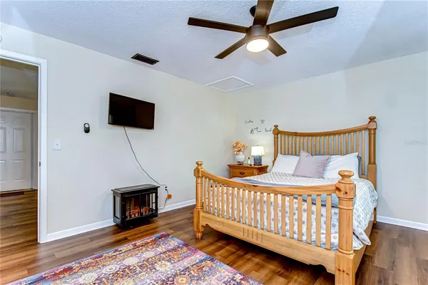 a bedroom with a bed a flat screen tv and a chandelier