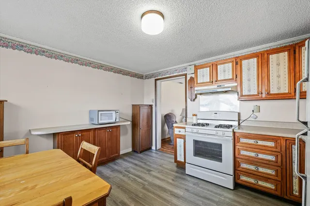 a dining room with wooden floor a chandelier a wooden table and chairs
