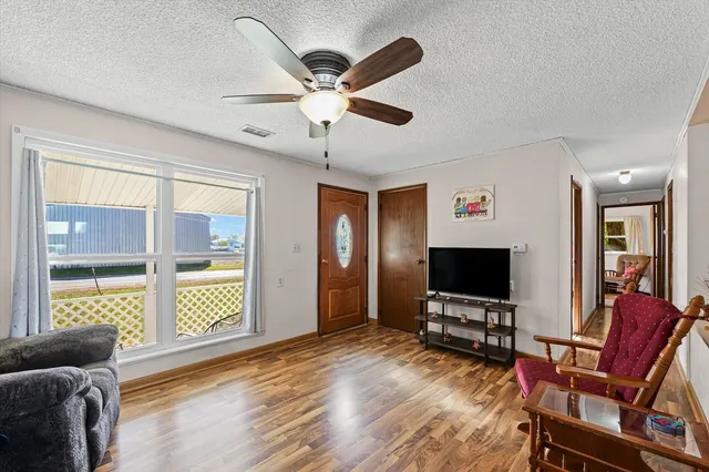 a view of a livingroom with furniture a flat screen tv and wooden floor