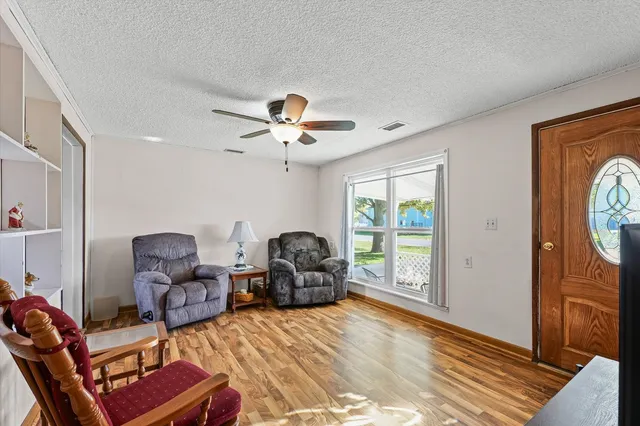 a kitchen with stainless steel appliances granite countertop a stove a refrigerator a sink dishwasher a dining table and chairs with wooden floor