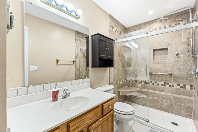 a bathroom with a sink a toilet and shower