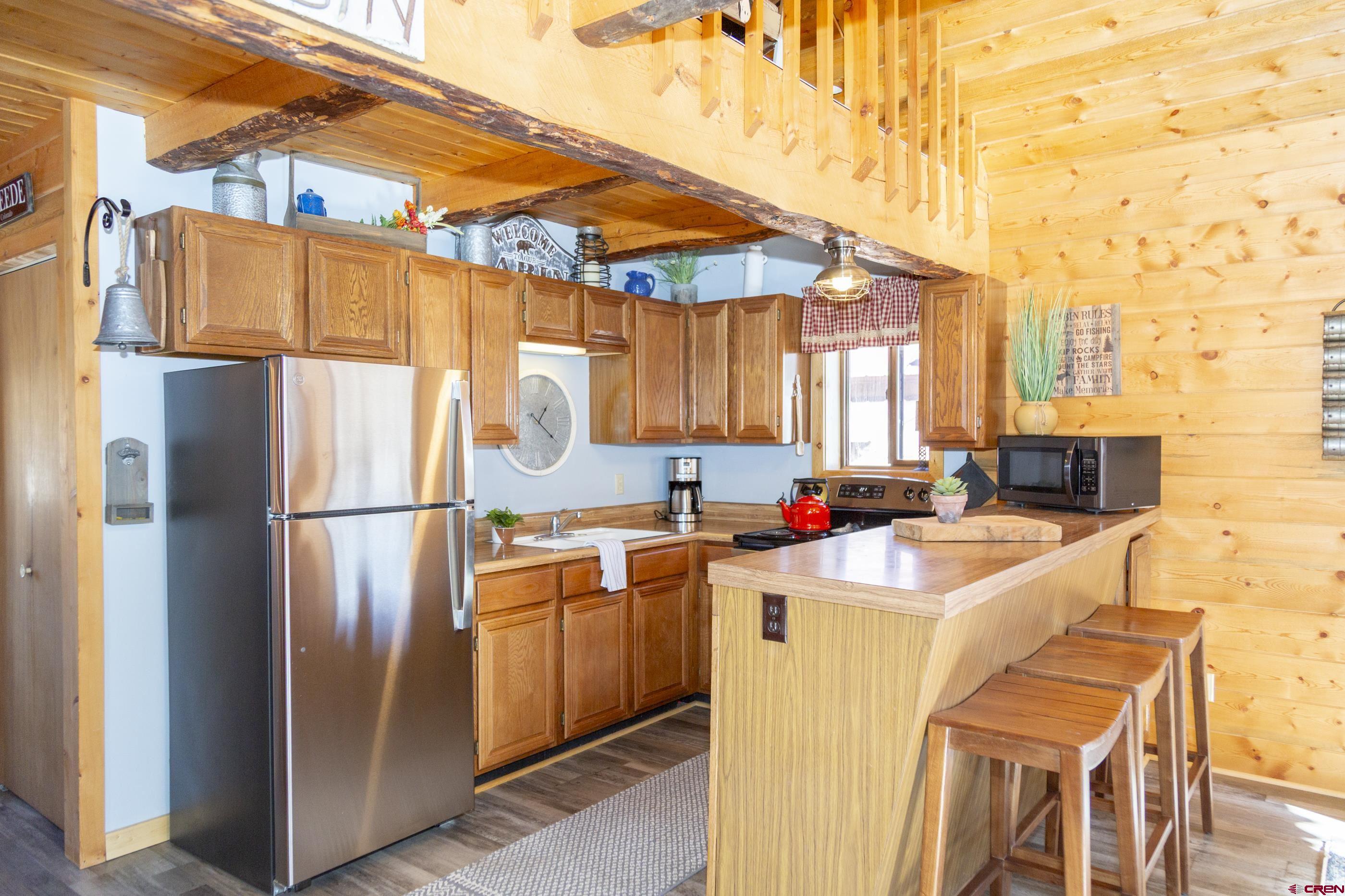 415 Ridge Drive Creede, CO 81130 - Photo 16 of 28 a kitchen with a sink a refrigerator and cabinets