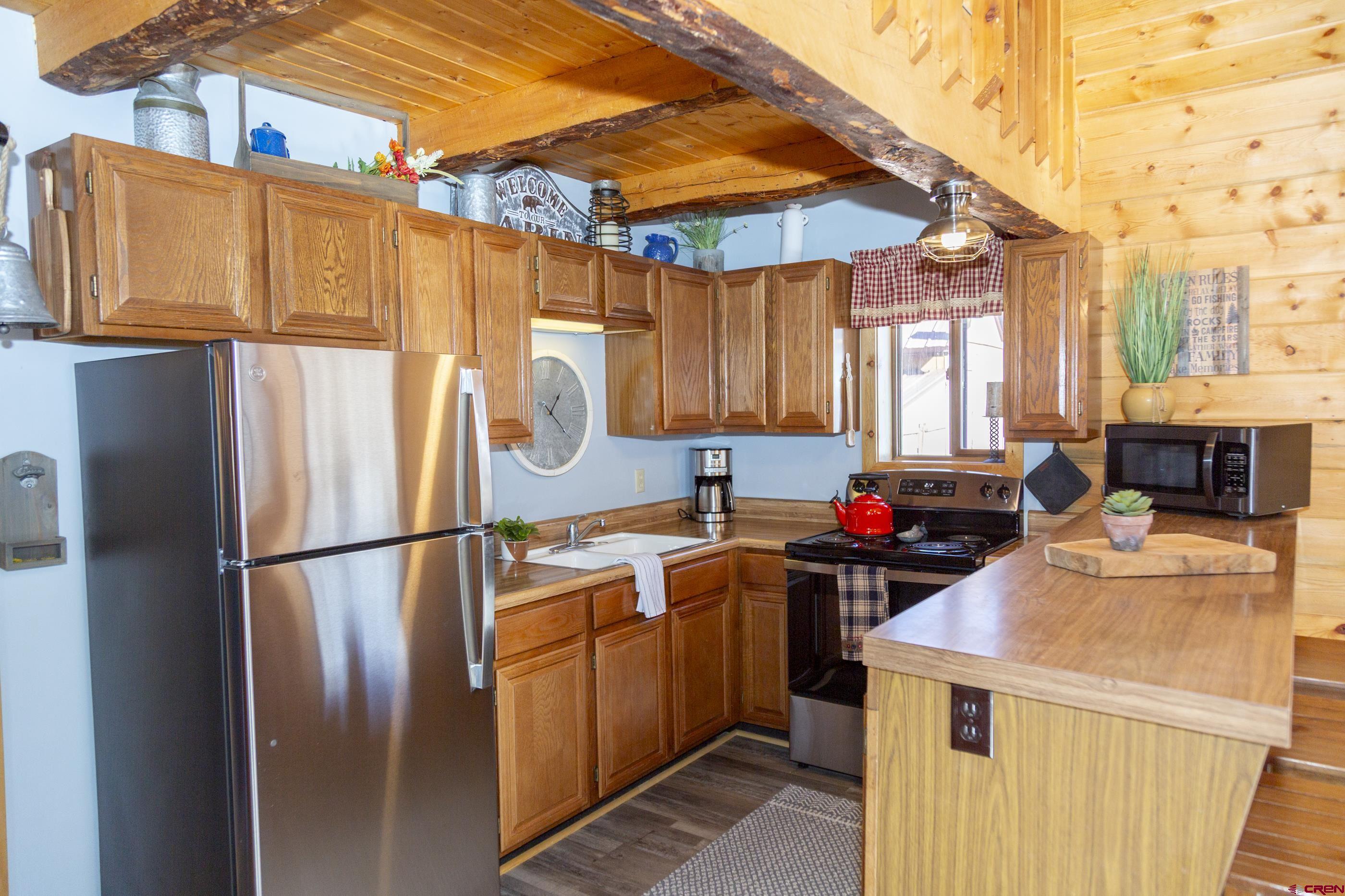 415 Ridge Drive Creede, CO 81130 - Photo 3 of 28 a kitchen with stainless steel appliances a refrigerator sink and cabinets