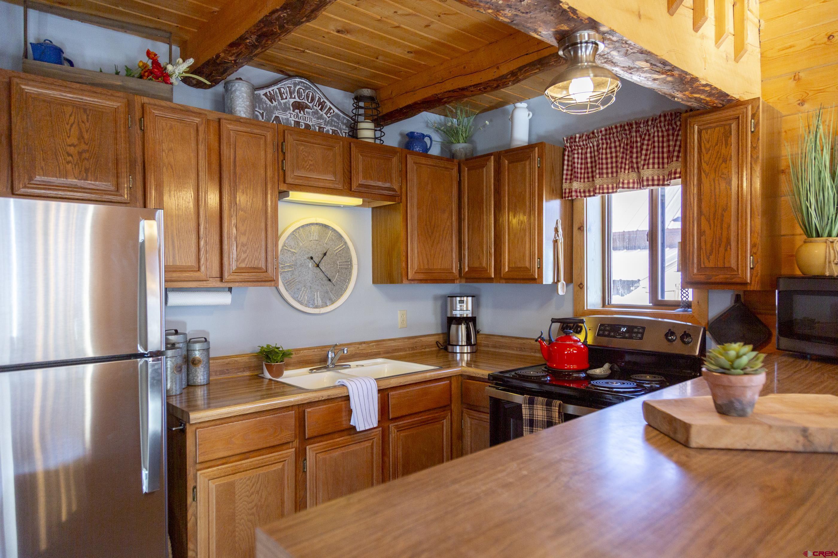 415 Ridge Drive Creede, CO 81130 - Photo 4 of 28 a kitchen with stainless steel appliances granite countertop a sink a stove and a refrigerator