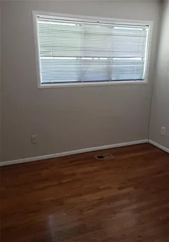 a view of a small space with wooden floor and a window