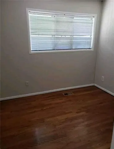 a view of a small space with wooden floor and a window