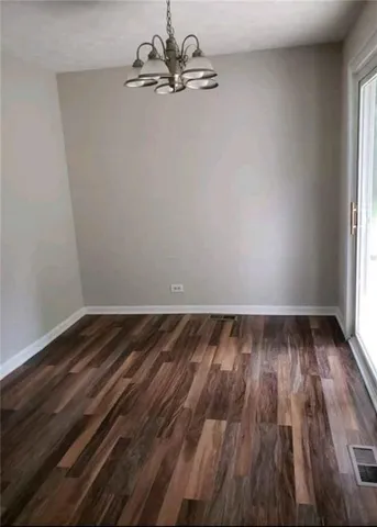 a view of a room with wooden floor and white walls