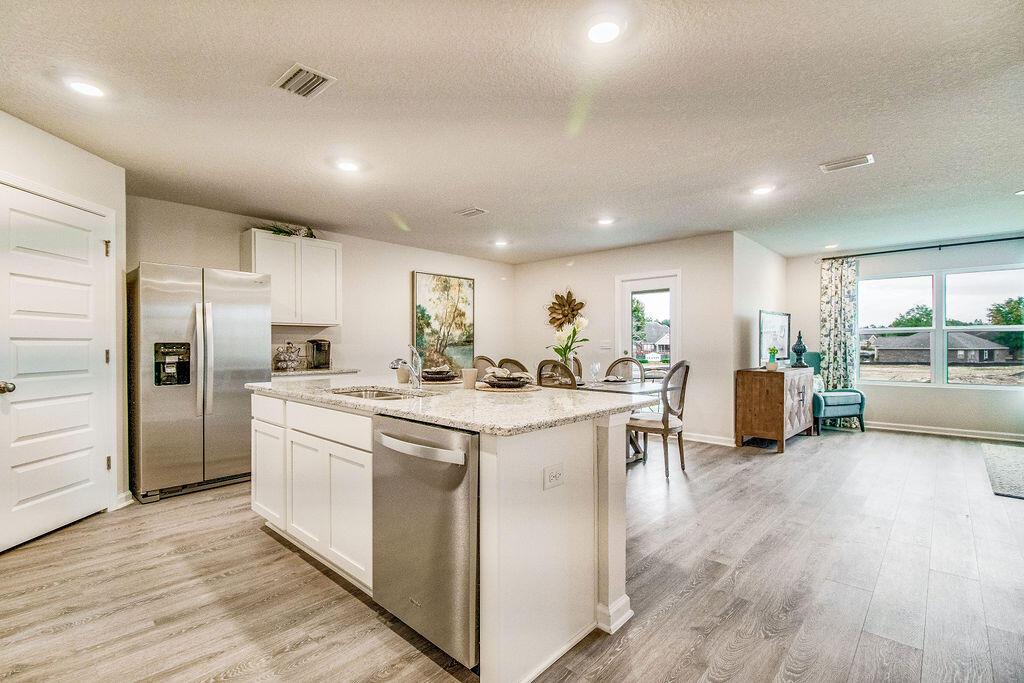 2851 Patriot Ridge Way Crestview, FL 32539 - Photo 2 of 34 a kitchen with stainless steel appliances kitchen island granite countertop a stove and a refrigerator