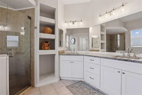 a spacious bathroom with a granite countertop sink mirror and shower
