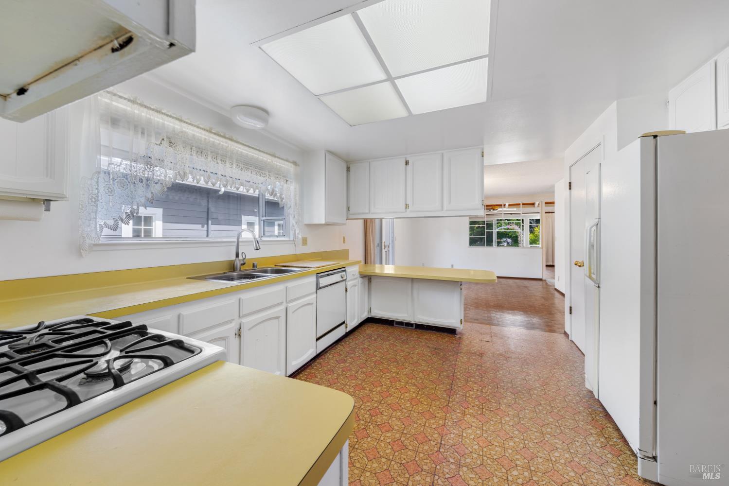 32 Roosevelt Avenue San Rafael, CA 94903 - Photo 11 of 40 a kitchen with stainless steel appliances a stove a sink dishwasher a refrigerator white cabinets and wooden floor