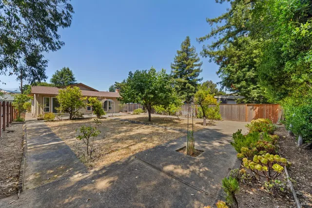 an aerial view of a house with a yard and large tree