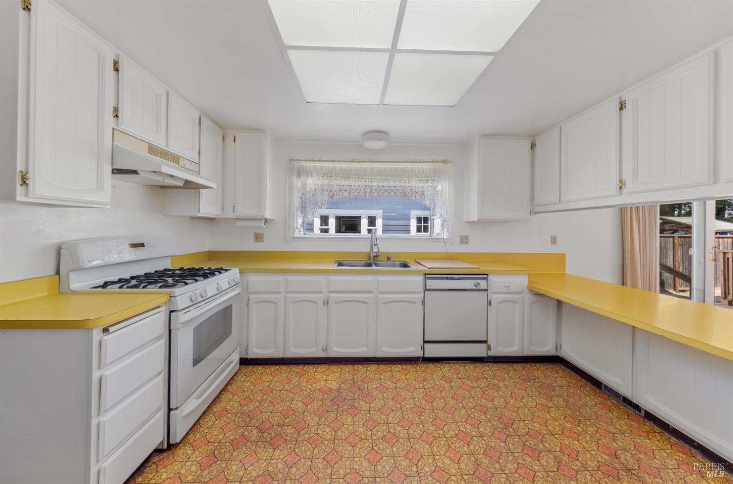 32 Roosevelt Avenue San Rafael, CA 94903 - Photo 10 of 40 a large kitchen with a lot of white cabinets and stainless steel appliances
