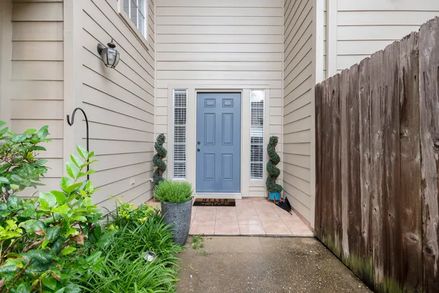 a view of house with backyard and potted plants
