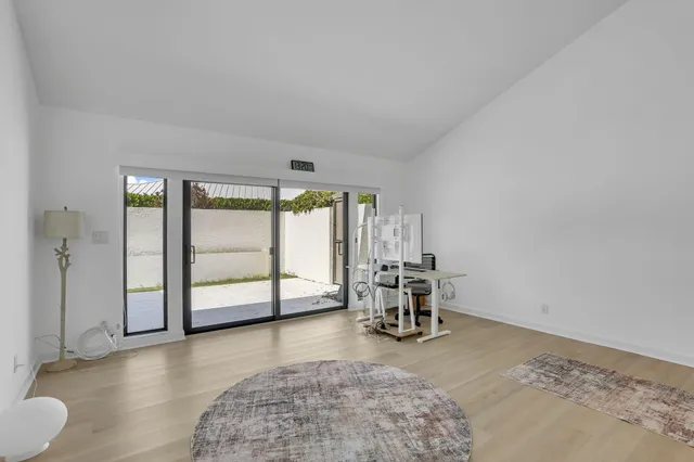 a view of a house next to a yard and palm trees