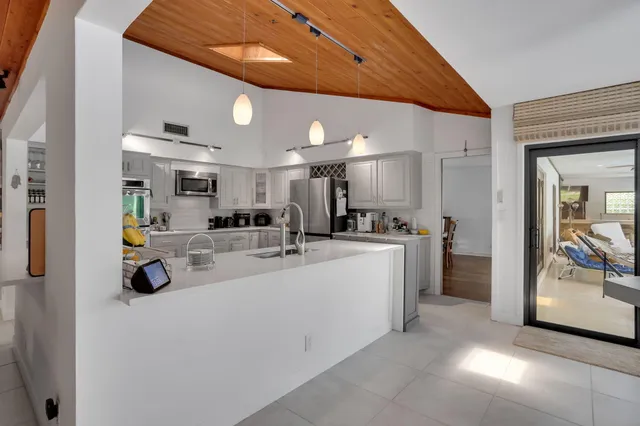 a large kitchen with stainless steel appliances lots of counter space sink and stove