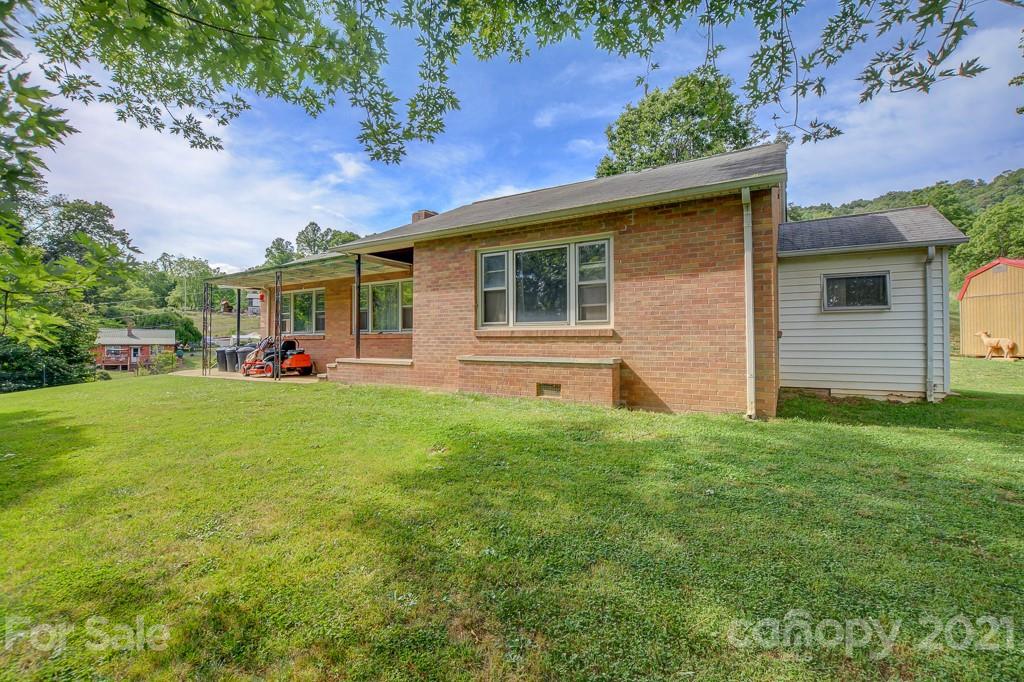 a front view of house with yard and trees in the background