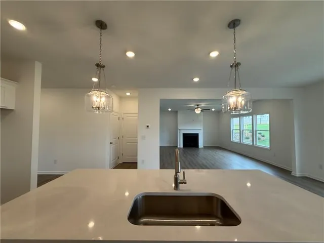 a kitchen with kitchen island a sink stainless steel appliances and chandelier