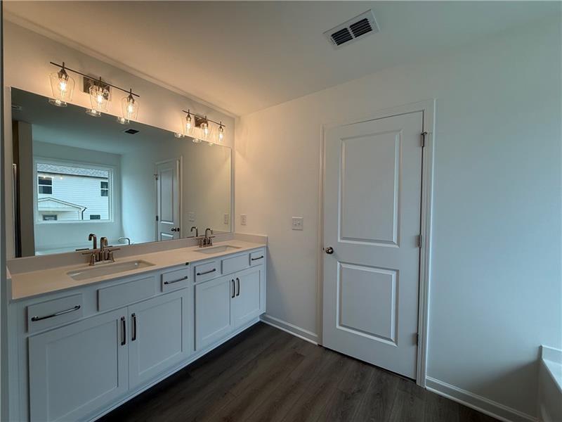 5449 Hargrove Way Flowery Branch, GA 30542 - Photo 24 of 39 a spacious bathroom with a double vanity sink and mirror