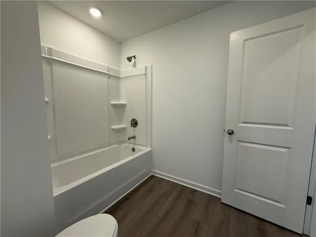 a bathroom with a granite countertop toilet sink a mirror and shower