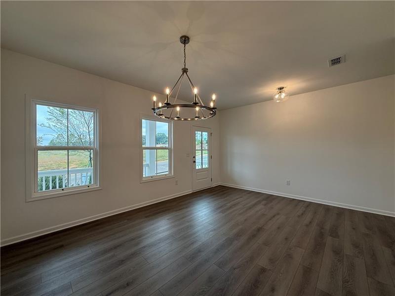 5449 Hargrove Way Flowery Branch, GA 30542 - Photo 4 of 39 a view of an empty room with wooden floor and a window