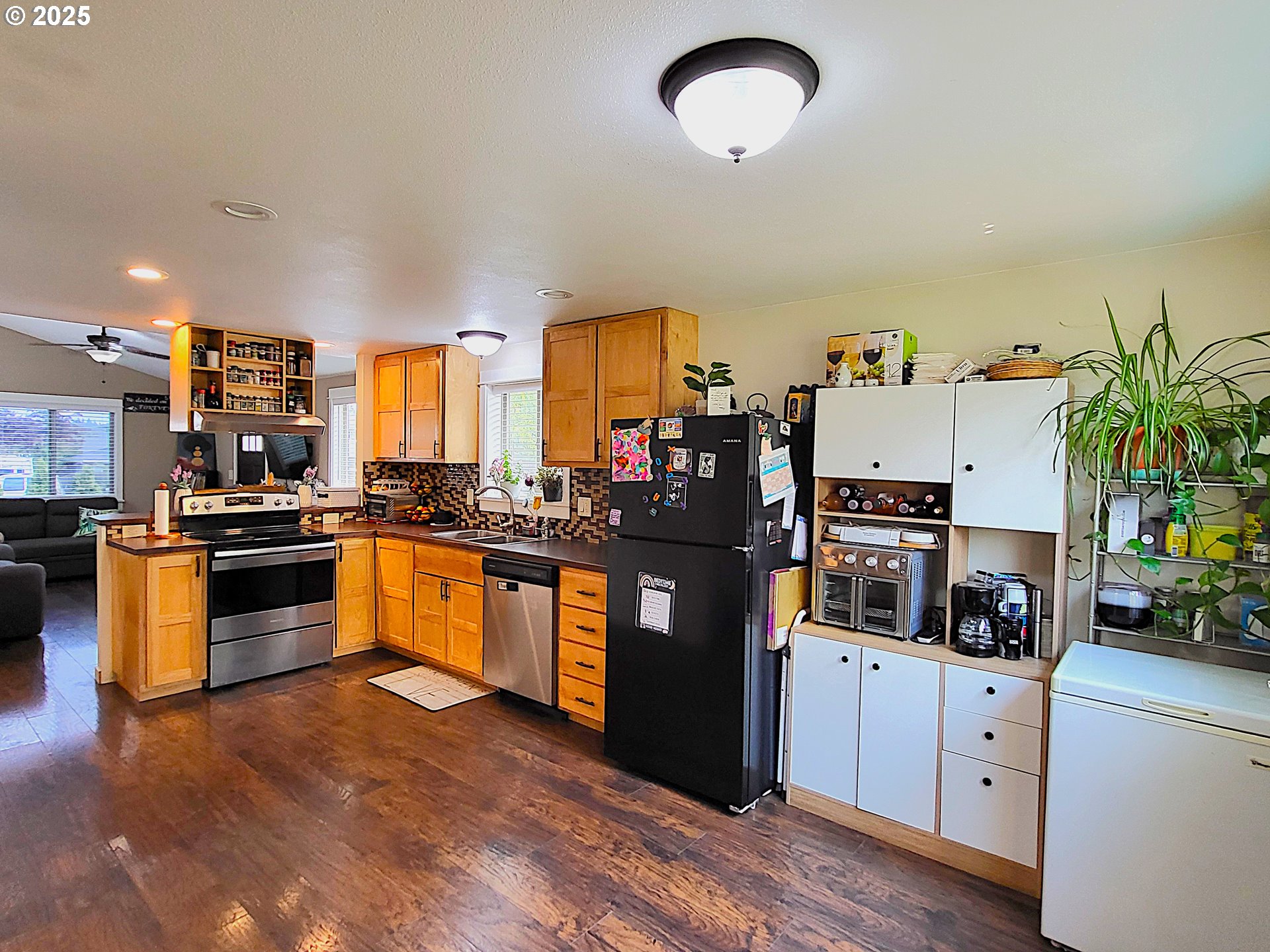 1727 East Washington Avenue Cottage Grove, OR 97424 - Photo 4 of 20 a kitchen with stainless steel appliances granite countertop a refrigerator a stove a sink and a microwave